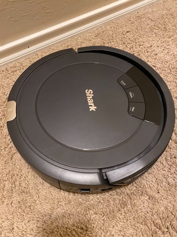 reviewer pic of the round grey robot vacuum