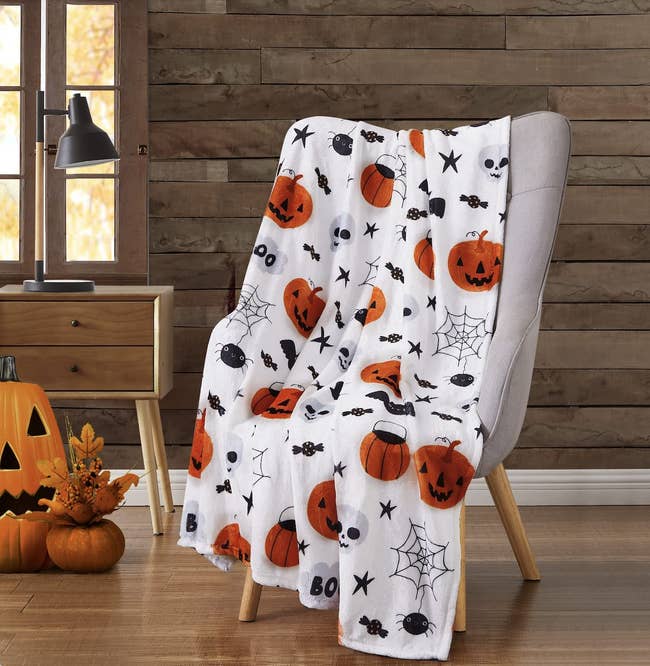 soft blanket with pumpkins spiders and skulls on the front 