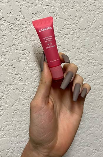 reviewer holding a tube of Laneige lip balm