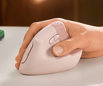 model's hand on the pink vertical mouse