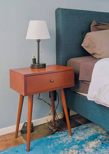 reviewer photo of wooden midcentury nightstand next to bed