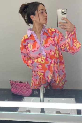 Another reviewer taking a mirror selfie in the pink floral set