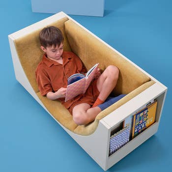 Child sitting successful a modern seat with built-in storage, speechmaking a book. The seat is designed for comfortableness and compact surviving spaces