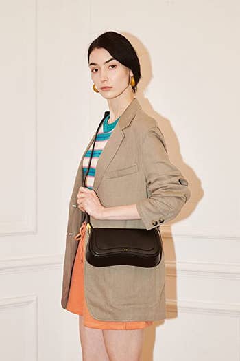 model wearing the bag in black as a crossbody