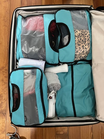 reviewer's suitcase filled with same packing cubes that have folded clothes