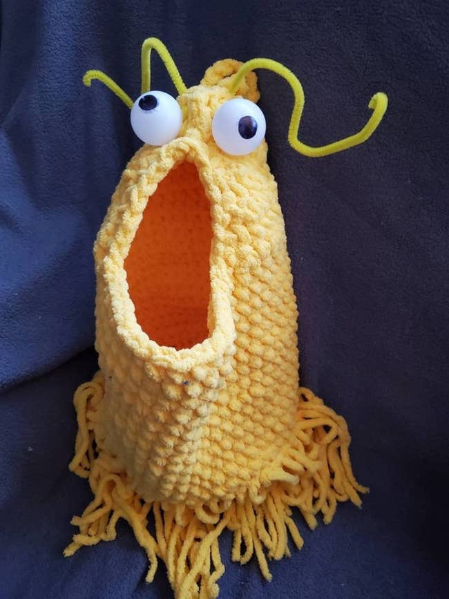a yellow crochet bag that looks like a Yip Yip from Sesame Street