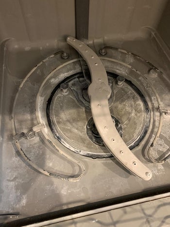 a reviewer photo of a dirty dishwasher interior
