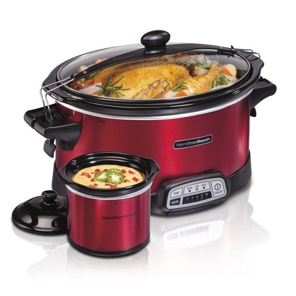 A red slow cooker with a turkey inside and a smaller slow cooker with queso dip