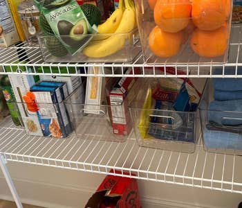 Pantry shelves neatly organized with various food items and clear storage bins