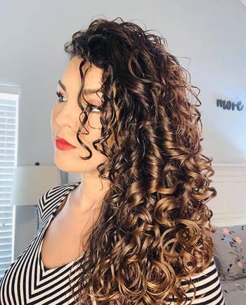 image of reviewer with long, shiny curly hair after using the protein treatment