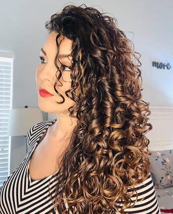 image of reviewer with long, shiny curly hair after using the protein treatment