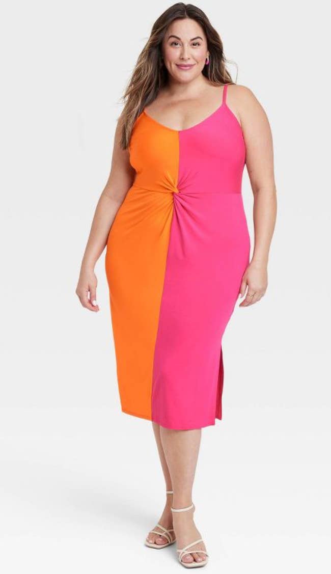 A model wearing a color-blocking dress in orange and pink