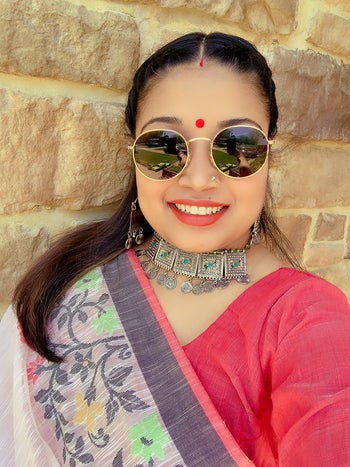 a reviewer wearing the gold framed lenses