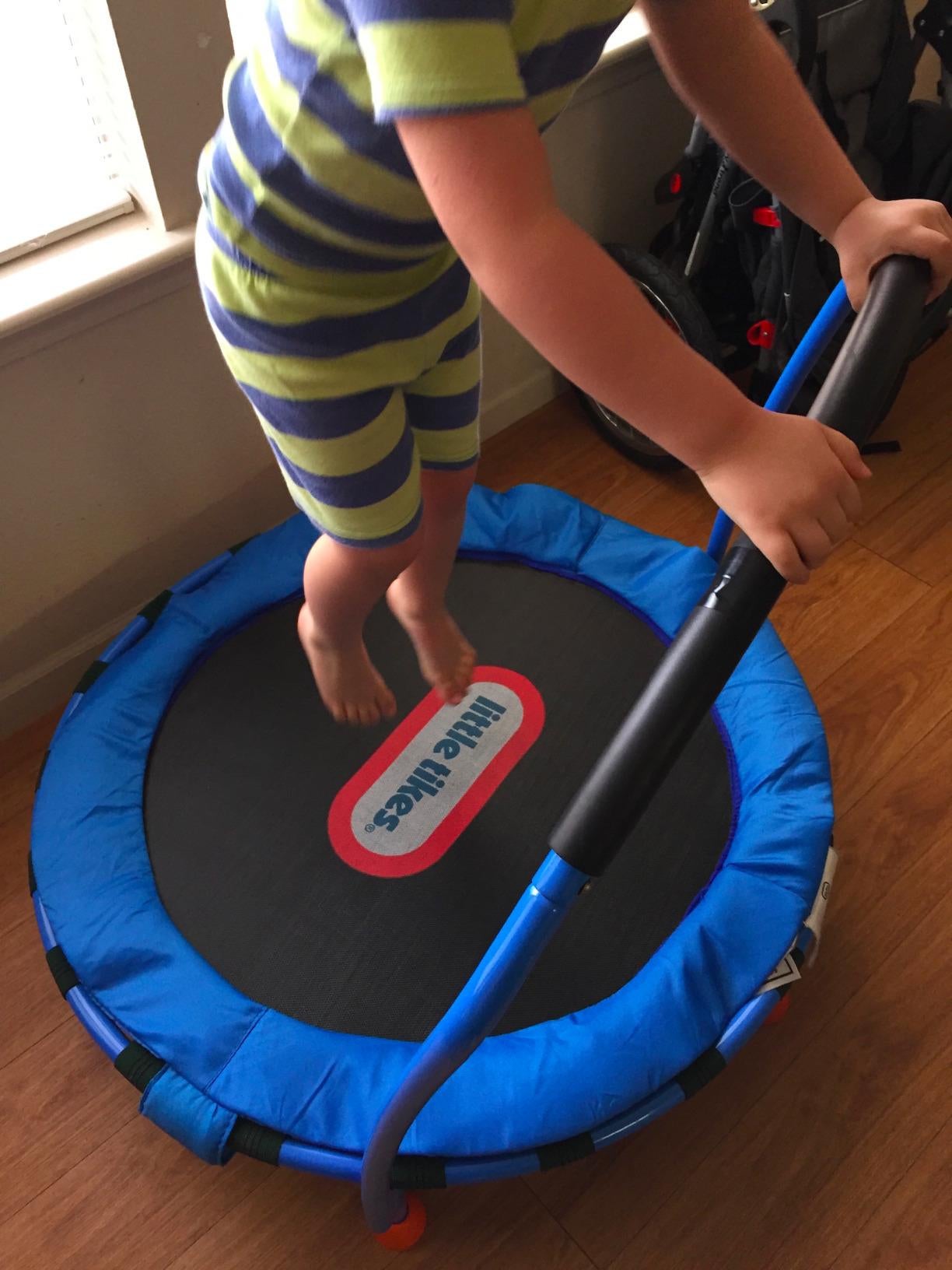 a reviewer's child jumping on the blue mini trampoline