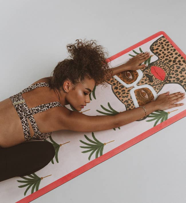 model laying on mat with an illustration of a fierce cheetah created by artist Kendra Dandy