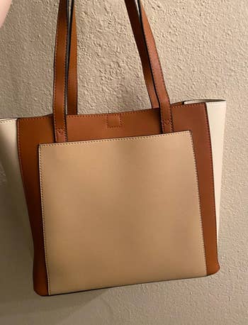 a reviewer photo of the tote bag in colorblock shades of brown 