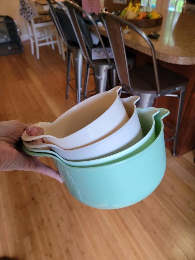 reviewer holding the four green ombre mixing bowls