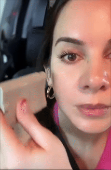 A reviewer is applying sunscreen with a contoured balm instrumentality   