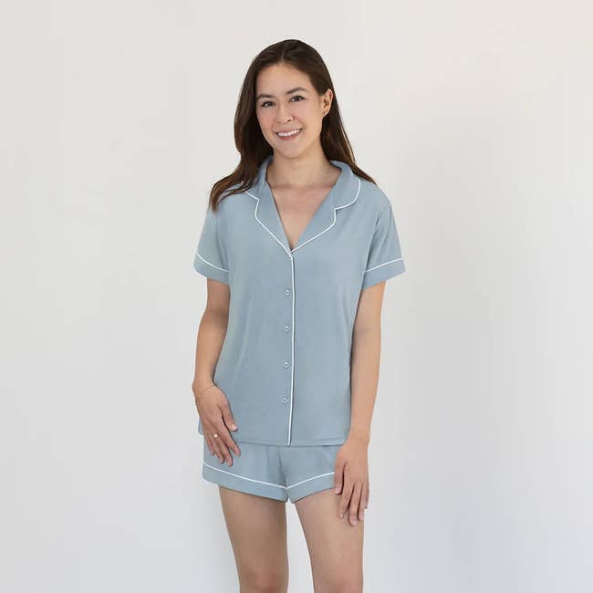 a model in a light blue collared button down pajama shirt and coordinating shorts
