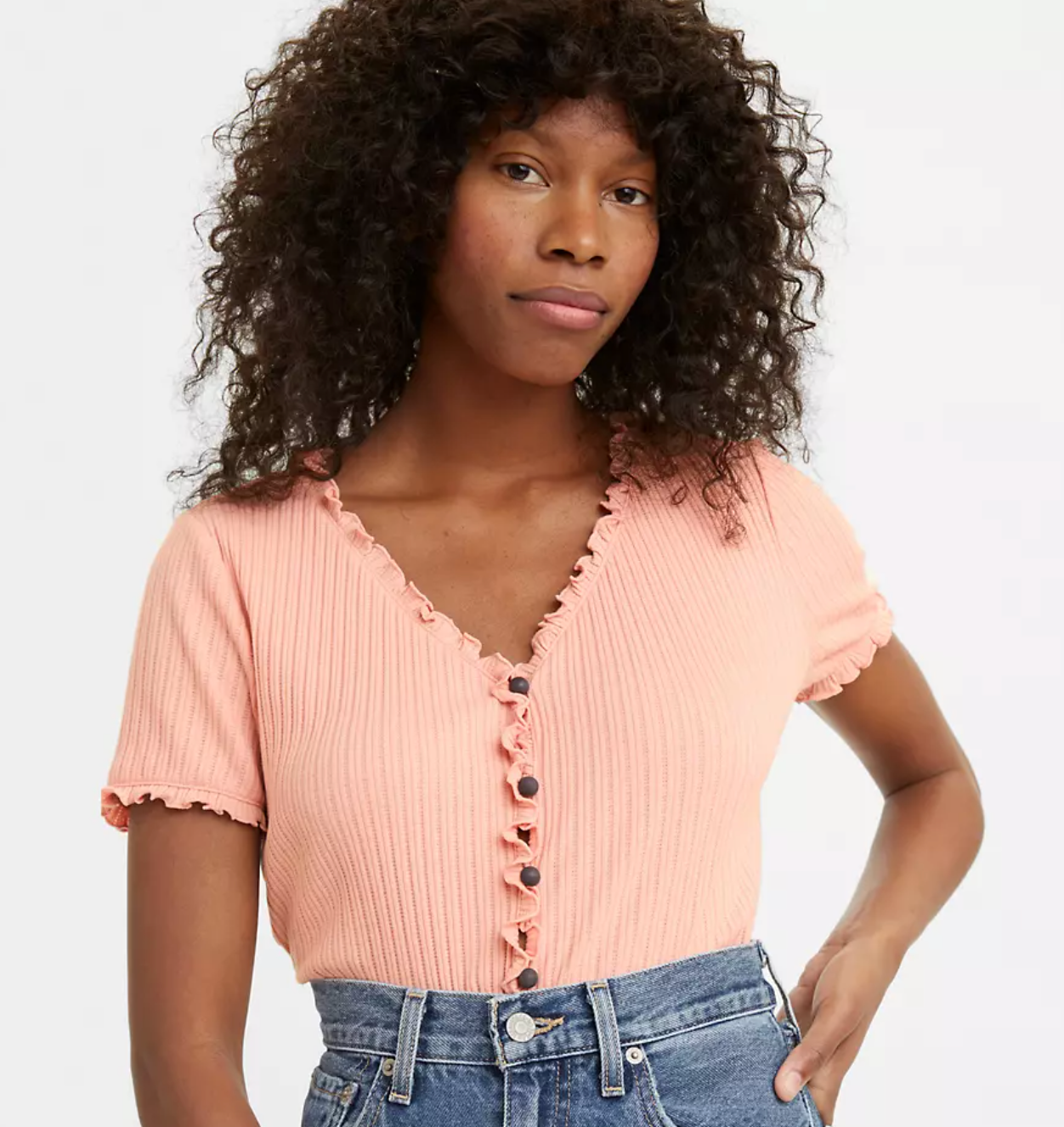 a person wearing a coral button up shirt