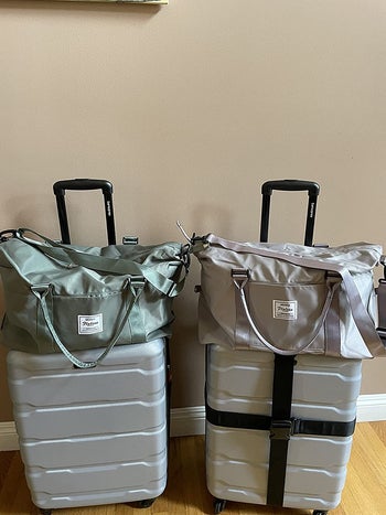 reviewer photo of two duffels — one green and one gray — on top of rolling suitcases