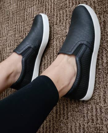 side view of reviewer wearing the black slip ons