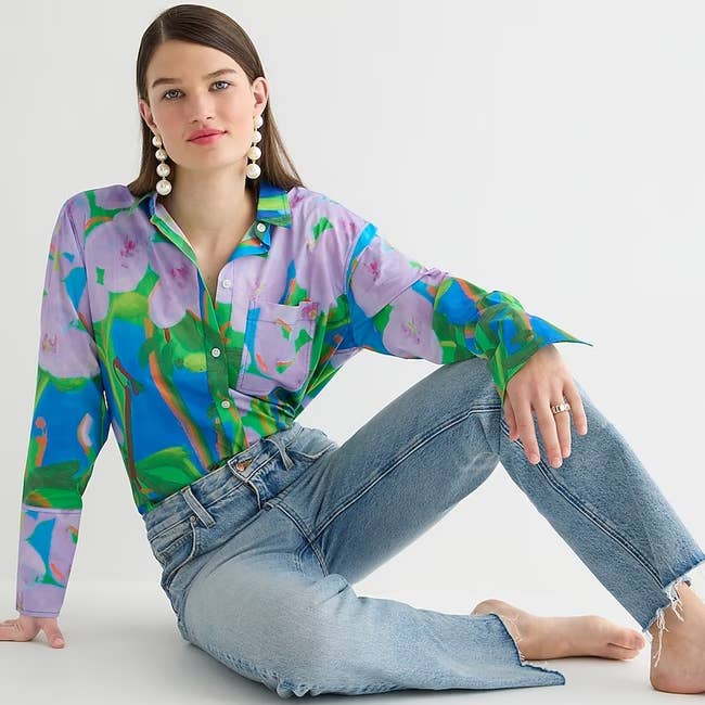 model wearing the purple, blue, and green printed button-down shirt