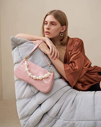 model holding pink jw pei bag with chunky pearl strap