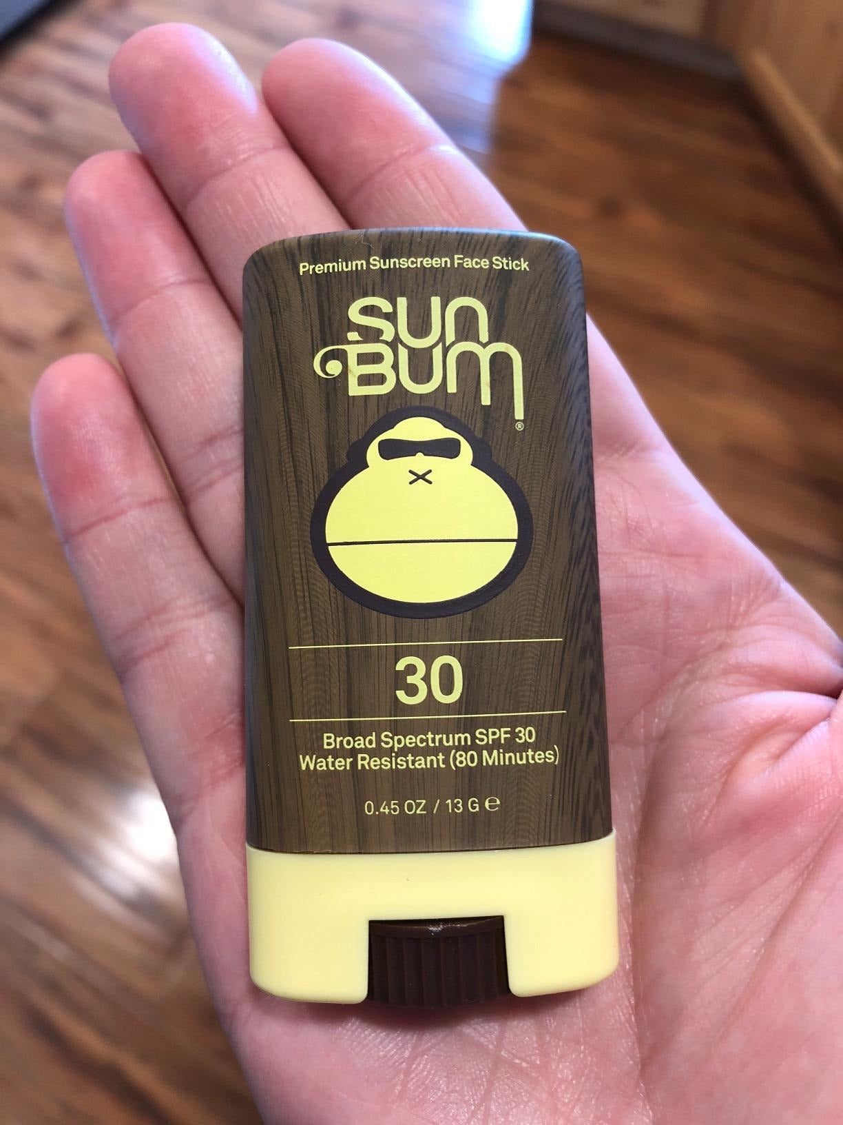 image of the sunscreen stick in the palm of a reviewer's hand