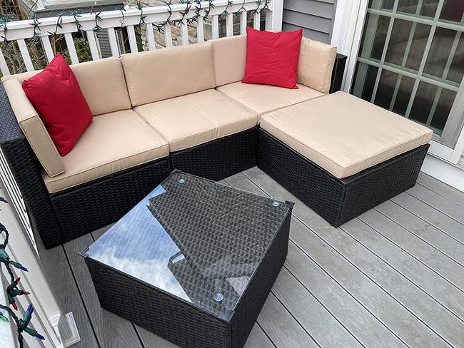 reviewer's sectional on their patio with red throw pillows