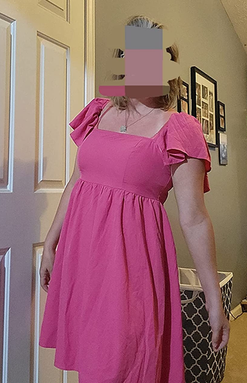 Reviewer wearing hot pink baby doll dress with ruffle short sleeves