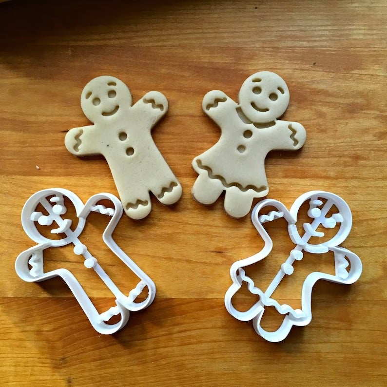 two gingerbread cookie cutters and the dough in their shape