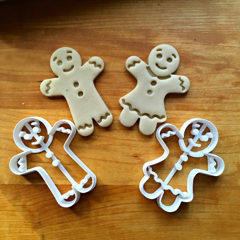two gingerbread cookie cutters and the dough in their shape