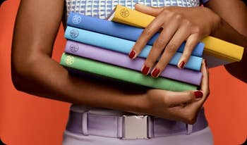 Person holding five colorful yoga blocks, showcasing variety and style