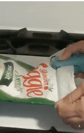 A reviewer sealing up a bag of chips with the small device 