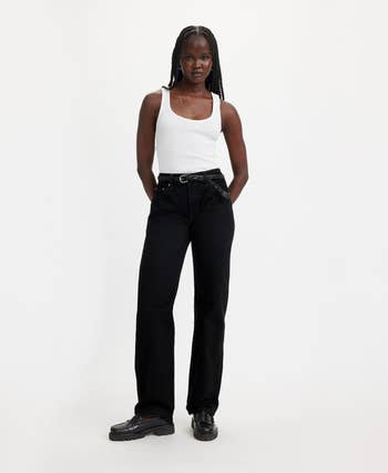 Model wearing a tank top with black jeans and chunky sole shoes