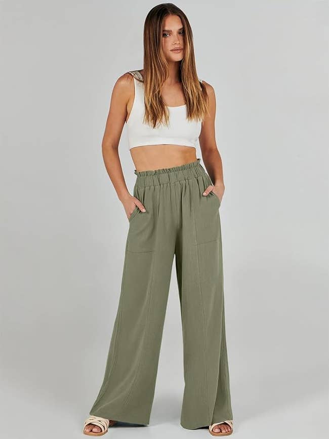 a model wearing olive wide-leg trousers with a white crop top