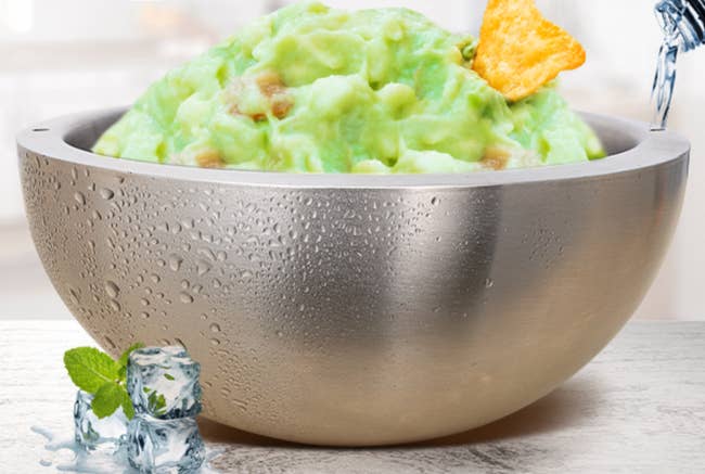A metal bowl with guac inside it 