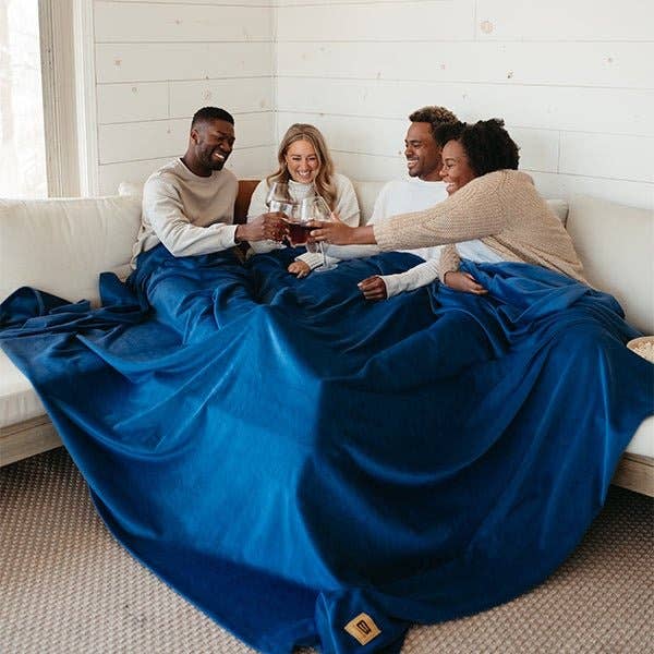 four models under the large blue velvet blanket