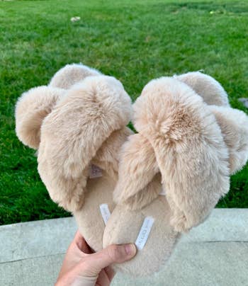 reviewer holding slippers in beige color