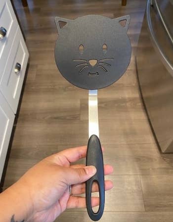 A black spatula in the shape of a cat's head 
