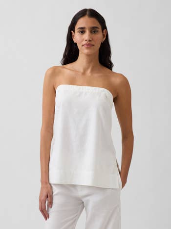 Person wearing a strapless achromatic apical and achromatic pants, lasting confidently