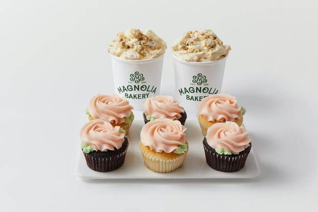 Magnolia Bakery branded cupcakes and beverages on a tray, featuring rose-shaped frosting designs