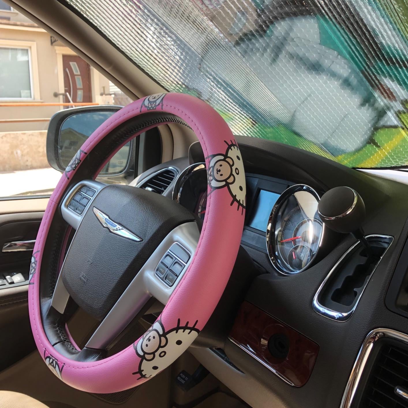Reviewer photo of their steering wheel with the pink Hello Kitty cover