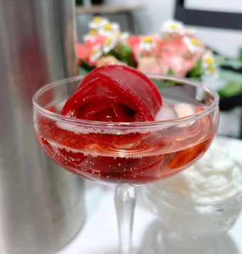 A red colored ice rose in a cocktail 