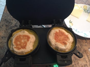 A reviewer demonstrating how the sandwich maker works with ingredients still uncooked