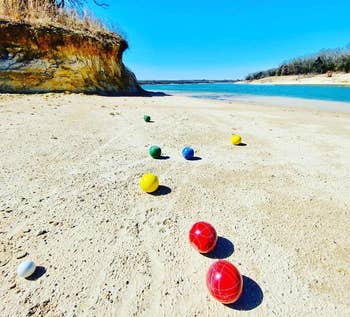 reviewer photo of the bocce balls on a sandy beach