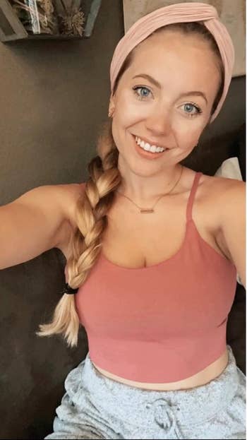 reviewer wearing a headband and tank top smiles for a selfie