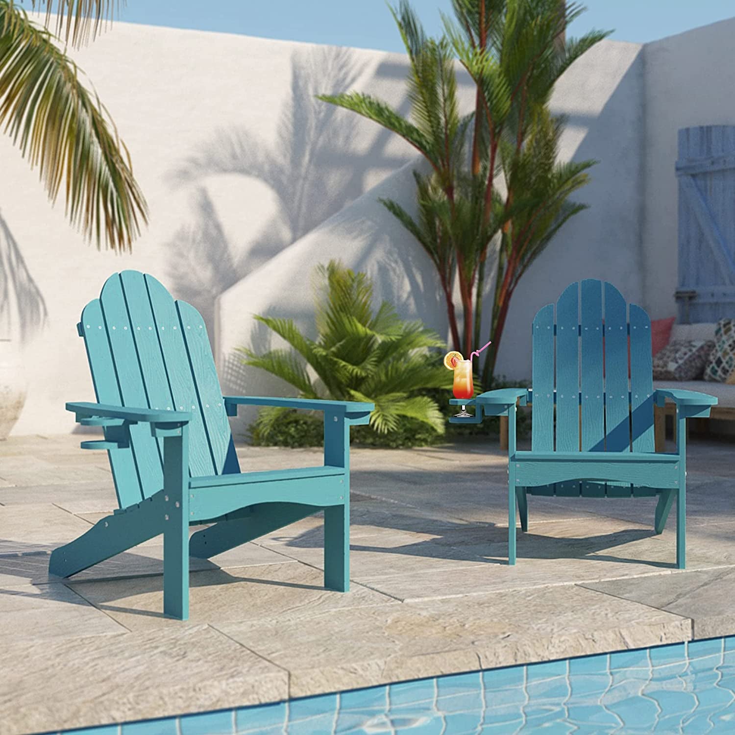 two teal Adirondack chairs next to a pool