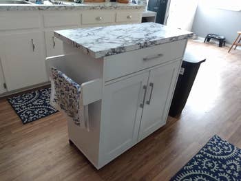 after of same island with marble wallpaper on counter